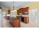 Spacious kitchen with dark wood cabinetry, granite countertops, and tile flooring at 1253 Oakwood Pl, Loganville, GA 30052