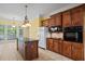 Bright kitchen with an island, tile floors, dark wood cabinets, and stainless steel appliances at 1253 Oakwood Pl, Loganville, GA 30052