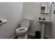 Powder room with pedestal sink, white toilet, and neutral tile flooring at 13030 Crabapple Lake Dr, Roswell, GA 30076