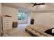 This carpeted bedroom features a ceiling fan, window, and a white dresser at 13030 Crabapple Lake Dr, Roswell, GA 30076