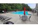 Inviting community pool featuring lounge chairs, tables with umbrellas, and ample deck space for residents to relax at 13030 Crabapple Lake Dr, Roswell, GA 30076