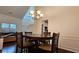 Dining room with a chandelier, wainscoting, and a classic wooden dining table that connects to the living area at 13030 Crabapple Lake Dr, Roswell, GA 30076