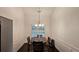 Inviting dining room with an elegant chandelier, wainscoting, and a classic wooden dining table with chairs at 13030 Crabapple Lake Dr, Roswell, GA 30076