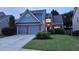 This two-story home features a brick facade, attached two-car garage, and manicured lawn at 13030 Crabapple Lake Dr, Roswell, GA 30076