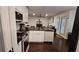 Modern kitchen with stainless steel appliances, black countertops, white cabinets, and seamless flow to living area at 13030 Crabapple Lake Dr, Roswell, GA 30076