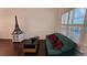 Cozy living room with wainscoting, hardwood floors, and a comfortable couch by a window with shutters at 13030 Crabapple Lake Dr, Roswell, GA 30076
