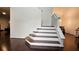 Elegant staircase with hardwood steps and white risers, complemented by rich hardwood floors and bright white walls at 13030 Crabapple Lake Dr, Roswell, GA 30076