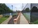 Well-maintained tennis court with a covered gazebo and landscaped surroundings for a pleasant playing experience at 13030 Crabapple Lake Dr, Roswell, GA 30076