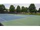 Well-maintained tennis courts with green and blue surfacing, offering a recreational amenity for residents at 13030 Crabapple Lake Dr, Roswell, GA 30076