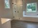 Luxurious bathroom with a glass-enclosed shower, soaking tub, tile floors, and plenty of natural light at 2021 Shallowford Rd, Marietta, GA 30066