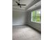 Spacious bedroom with a ceiling fan, a large window overlooking a wooded lot, and plush carpet at 2021 Shallowford Rd, Marietta, GA 30066