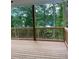 A relaxing wooden deck overlooks a serene view of lush trees and tranquil water at 2021 Shallowford Rd, Marietta, GA 30066
