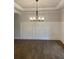 Formal dining room featuring wainscoting detail, hardwood floors, tray ceiling and elegant chandelier at 2021 Shallowford Rd, Marietta, GA 30066