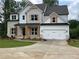 Beautiful two-story home with a brick and white facade, wood accents, and an attached two-car garage at 2021 Shallowford Rd, Marietta, GA 30066