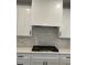 Close-up of a modern kitchen with white cabinets, subway tile backsplash, and a stainless steel range at 2021 Shallowford Rd, Marietta, GA 30066