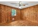 Bedroom with hardwood floors, wood paneled walls, and natural light from the window at 519 Beaver Ruin Nw Way, Lilburn, GA 30047