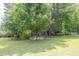 Lush green front yard with mature trees and landscaping offering shade and curb appeal at 519 Beaver Ruin Nw Way, Lilburn, GA 30047