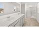 Bright bathroom features a double sink vanity with a white countertop and a glass-enclosed shower at 1473 Autumn Wind Dr, Dacula, GA 30019