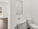 Compact bathroom features a pedestal sink and toilet, offering a practical space at 1483 Autumn Wind Dr, Dacula, GA 30019