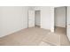 A bright, carpeted bedroom with neutral walls, a closet, and a doorway at 1483 Autumn Wind Dr, Dacula, GA 30019
