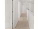 Hallway with neutral carpet, white walls, and white trim leading to various rooms at 1483 Autumn Wind Dr, Dacula, GA 30019