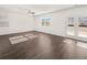 Well-lit living room with hardwood floors, a ceiling fan, and easy access to the outdoors at 1483 Autumn Wind Dr, Dacula, GA 30019
