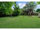 Spacious backyard with lush lawn, a playhouse, and a deck with stairs leading up to the house at 2324 Oakview Ne Rd, Atlanta, GA 30317