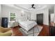 Bright main bedroom with a tray ceiling, two windows, wood floors, ceiling fan and neutral decor at 2324 Oakview Ne Rd, Atlanta, GA 30317