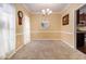 Bright dining room with neutral walls, carpet, and a glimpse of the kitchen at 2451 Broad River Pl, Ellenwood, GA 30294