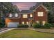 Charming two-story brick home with well-manicured lawn, mature trees, and an attached two-car garage at 2451 Broad River Pl, Ellenwood, GA 30294