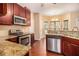 Updated kitchen with granite countertops, stainless steel appliances, and dark wood cabinets at 2451 Broad River Pl, Ellenwood, GA 30294