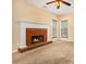 Cozy living room featuring a brick fireplace, plush carpet, and natural light from two windows at 2451 Broad River Pl, Ellenwood, GA 30294