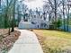 Charming two-story home featuring a stone accent wall, light gray siding, and a long driveway nestled in a wooded area at 5419 S Lake Dr, Douglasville, GA 30135