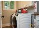 Bright laundry room featuring modern washer and dryer with extra cabinet space at 5419 S Lake Dr, Douglasville, GA 30135
