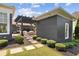 Landscaped backyard and outdoor living area with a stone fireplace and black pergola structure at 6815 Berkley Rd, Cumming, GA 30040