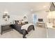 Neutral bedroom with a black comforter, white desk, black accent lights, and white trim throughout at 6815 Berkley Rd, Cumming, GA 30040