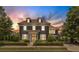 Charming two-story home with manicured lawn and elegant architectural details at dusk at 6815 Berkley Rd, Cumming, GA 30040