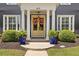 Inviting front entrance featuring a bright yellow double door, flanked by potted plants and manicured hedges at 6815 Berkley Rd, Cumming, GA 30040