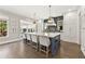 Spacious kitchen featuring a large center island with seating, stainless steel appliances, and pendant lighting at 6815 Berkley Rd, Cumming, GA 30040