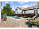 Backyard pool with lounge chairs, lush landscaping, brick patio and a modern white home at 6815 Berkley Rd, Cumming, GA 30040
