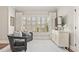 Bright sitting room with two chairs, white cabinets, large window and light gray carpet at 6815 Berkley Rd, Cumming, GA 30040