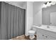 Neutral bathroom features a toilet, shower with gray curtain, and a vanity with sink at 2207 Concordia Se Way # 12, Mableton, GA 30126