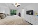 Bright main bedroom featuring a ceiling fan, balcony access, and large dresser with flatscreen TV at 2808 Vinings Central Se Dr # 158, Atlanta, GA 30339