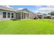 Expansive backyard view featuring a well-maintained lawn, a screened-in porch, and neighboring properties at 215 Windsor Park Dr, Woodstock, GA 30188