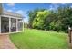 A view of the backyard with a screened-in porch and lush green lawn at 215 Windsor Park Dr, Woodstock, GA 30188