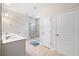 Bright bathroom boasts double sink vanity and tiled walk-in shower with seamless glass doors at 215 Windsor Park Dr, Woodstock, GA 30188