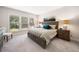 Bright bedroom with a queen bed, decorative lamps, and three-panel windows at 215 Windsor Park Dr, Woodstock, GA 30188