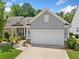 Charming single-Gathering home featuring a two-car garage and manicured front yard at 215 Windsor Park Dr, Woodstock, GA 30188