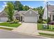 Charming one-story home with a well-manicured lawn, an attached two-car garage, and a welcoming front porch at 215 Windsor Park Dr, Woodstock, GA 30188