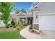 Inviting home with a covered porch, featuring attractive landscaping, a two-car garage, and a well-lit pathway at 215 Windsor Park Dr, Woodstock, GA 30188